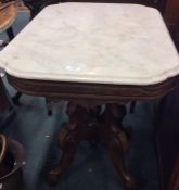 An Edwardian oak and marble topped occasional tabl
