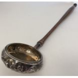 An unusual silver ladle with embossed decoration.