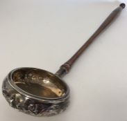 An unusual silver ladle with embossed decoration.