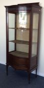 An Edwardian mahogany serpentine cabinet with bead