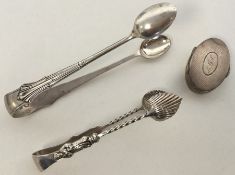 An oval silver pill box together with silver tongs