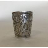A small silver embossed spirit tot decorated with
