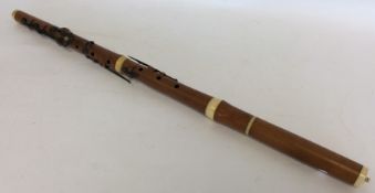 An old wooden flute with ivory inserts. Retailed b