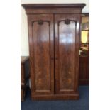 A mahogany two door wardrobe decorated with scroll