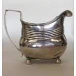 A good Georgian silver reeded cream jug on ball fe
