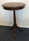 A mahogany pillar table decorated with scrolls on