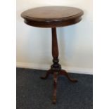 A mahogany pillar table decorated with scrolls on