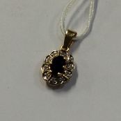 A small sapphire and diamond pendant in 18 carat g