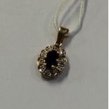 A small sapphire and diamond pendant in 18 carat g