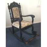 A massive Colonial carved rocking chair with scrol