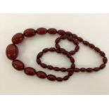 A graduated string of red amber beads. Approx. 57