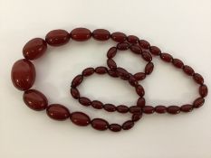 A graduated string of red amber beads. Approx. 57