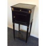 An ebony and gilded pot cupboard on tapering legs