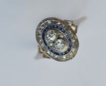 A sapphire and diamond oval cluster ring in two-co