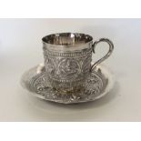 A heavy Indian silver cup with matching saucer, he