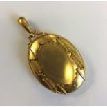 A large heavy oval locket with loop top and fitted