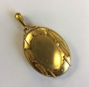 A large heavy oval locket with loop top and fitted