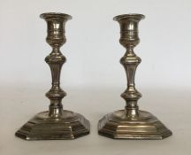 A pair of Georgian style silver candlesticks, the