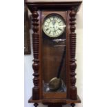 A large mahogany regulator wall clock with twisted