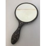 An attractively embossed silver hand mirror decora