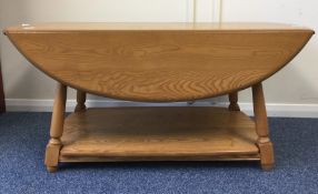 ERCOL: A good oval occasional table on spreading s