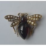 A large cabochon garnet and pearl brooch in the fo