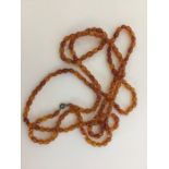 A graduated string of faceted amber beads. Approx.