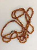 A graduated string of faceted amber beads. Approx.