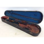 An old violin in case together with a bow. Marked