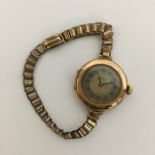 ROLEX: A lady's gold cased wristwatch with silvere
