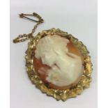 An oval cameo of a lady's head in gold frame. Appr