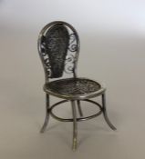 A novelty miniature silver chair with filigree dec