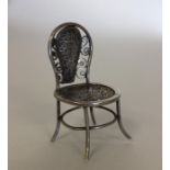 A novelty miniature silver chair with filigree dec