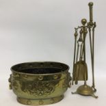 An old brass log crock decorated with scrolls and