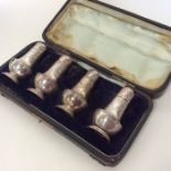 A cased set of four baluster shaped silver peppers