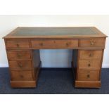 A nine drawer mahogany twin pedestal desk with lea