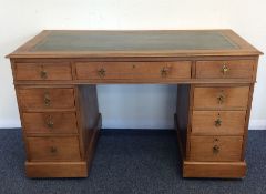 A nine drawer mahogany twin pedestal desk with lea