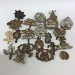 A large collection of cap badges. Est. £20 - £30.