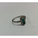 An Art Deco emerald and diamond step cut cluster r