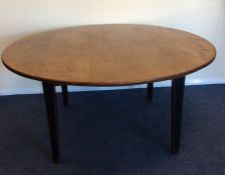 A large rustic oak circular dining table on taperi