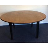 A large rustic oak circular dining table on taperi