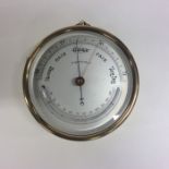 A brass cased aneroid barometer with silvered dial
