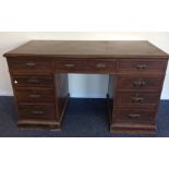 An Edwardian nine drawer twin pedestal desk with p