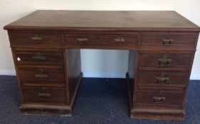 An Edwardian nine drawer twin pedestal desk with p