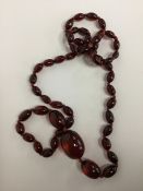 A graduated string of red amber beads. Approx. 70