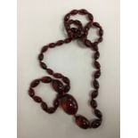 A graduated string of red amber beads. Approx. 70