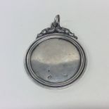 A Georgian silver medallion with scroll decoration