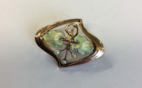An attractive enamel brooch decorated with pearls