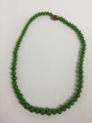 A graduated hard stone bead necklace with hair cla