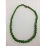 A graduated hard stone bead necklace with hair cla